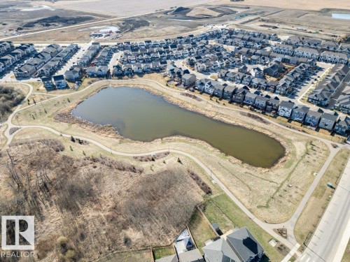 Aerial perspective showcasing a residential development with a central pond feature - 2011 207 Street, Edmonton, AB - Outdoor With View