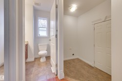 This functional space features a white toilet, a window with decorative privacy film, and a vanity with a countertop and cabinet - 