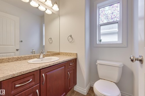 Bathroom featuring a vanity with a light-colored countertop, a white sink, and dark wood cabinetry with silver hardware - 24 Birchmont Drive, Leduc, AB - Indoor Photo Showing Bathroom
