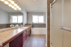 Bathroom featuring a vanity with a light-colored countertop, a built-in sink, and wood cabinetry - 