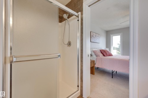 The property includes a shower with sliding doors, a hand-held showerhead, and a tiled shower wall - 24 Birchmont Drive, Leduc, AB - Indoor Photo Showing Bathroom