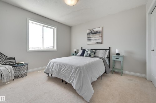 This room features light-colored carpeting, a window providing natural light, and a light-colored ceiling - 24 Birchmont Drive, Leduc, AB - Indoor Photo Showing Bedroom