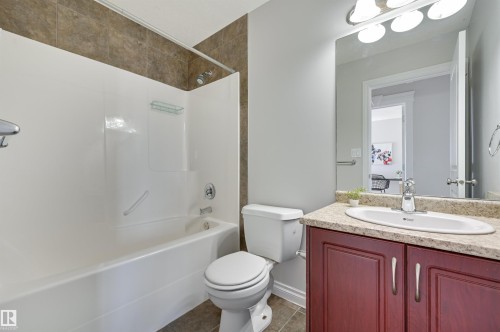 This bathroom features a bathtub with a shower, a toilet, and a vanity with a sink - 24 Birchmont Drive, Leduc, AB - Indoor Photo Showing Bathroom