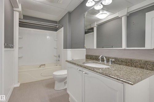 Bathroom featuring a vanity with a granite-style countertop, undermount sink, and polished chrome faucet - 24 Birchmont Drive, Leduc, AB - Indoor Photo Showing Bathroom