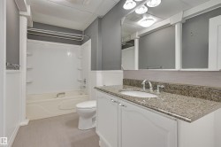 Bathroom featuring a vanity with a granite-style countertop, undermount sink, and polished chrome faucet - 