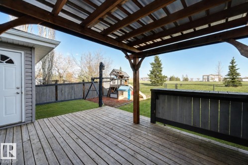 Expansive wood-finish deck featuring a wood pergola with metal roofing, offering outdoor living space - 24 Birchmont Drive, Leduc, AB - Outdoor With Deck Patio Veranda With Exterior