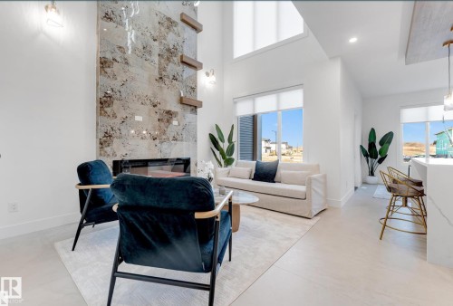 Living area featuring a tall fireplace with a natural stone surround and an integrated linear firebox - 4727 17 Avenue Sw, Edmonton, AB - Indoor