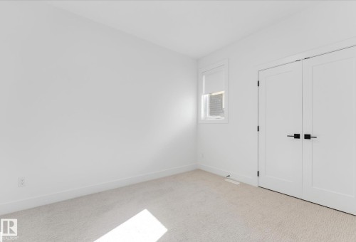 Neutral color palette featuring light-toned carpeting and white walls - 4727 17 Avenue Sw, Edmonton, AB - Indoor Photo Showing Other Room