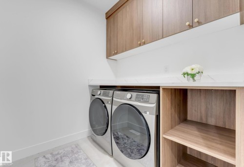 Laundry area featuring wood-finish cabinetry, white countertop, and built-in shelving - 4727 17 Avenue Sw, Edmonton, AB - Indoor Photo Showing Laundry Room