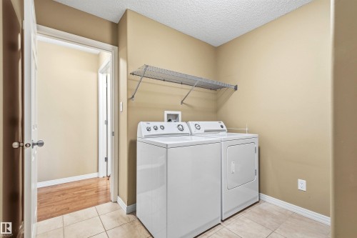 Dedicated utility space featuring neutral wall tones and tile flooring - 2340 Hagen Link, Edmonton, AB - Indoor Photo Showing Laundry Room