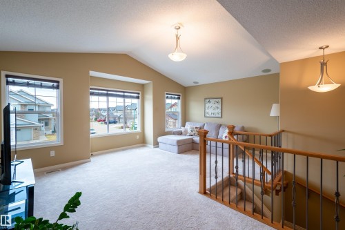 Spacious living area featuring vaulted ceilings, light-toned carpeting, and a bay window with ample natural light - 2340 Hagen Link, Edmonton, AB - Indoor Photo Showing Other Room