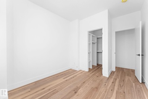 The room features light wood flooring, white walls, and bright overhead lighting - 11021 132 Street, Edmonton, AB - Indoor Photo Showing Other Room