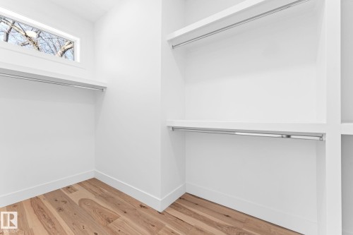 The property features a closet with hardwood flooring, white walls, and a window providing natural light - 11021 132 Street, Edmonton, AB - Indoor With Storage
