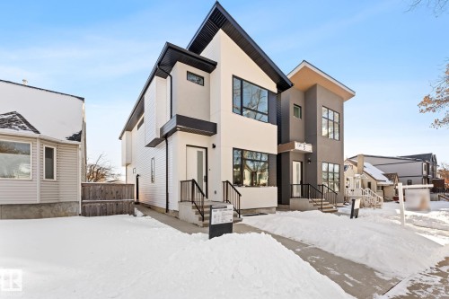 Modern architectural style property featuring a light-colored facade with contrasting dark trim and window frames, a concrete driveway, and a sloped roofline - 11021 132 Street, Edmonton, AB - Outdoor