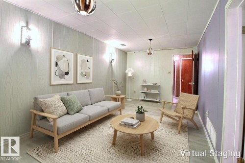Living room featuring light wood-finish wall paneling, ceiling-mounted light fixtures, wood-finish flooring, and white baseboards - 9512 134 Avenue, Edmonton, AB - Indoor Photo Showing Living Room