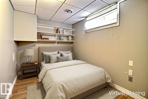 Recessed window with blinds, wood-finish flooring, drop ceiling, built-in shelving, and a wall-mounted enclosure - 9512 134 Avenue, Edmonton, AB - Indoor Photo Showing Bedroom