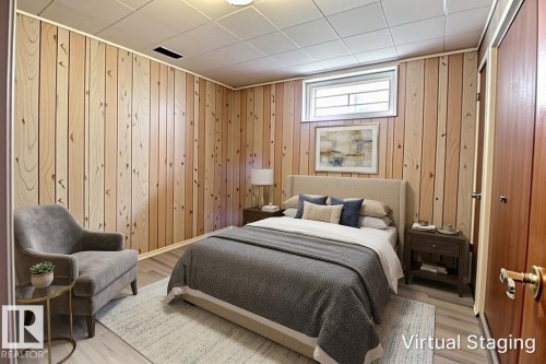 Vertical wood-paneling walls complement light wood-finish flooring - 9512 134 Avenue, Edmonton, AB - Indoor Photo Showing Bedroom
