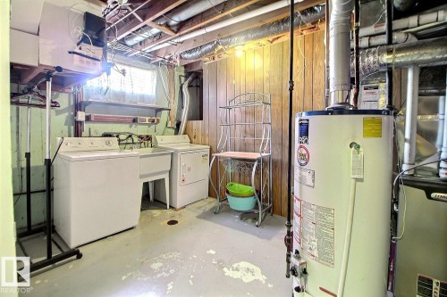 Laundry area featuring a utility sink, top-load washer, and front-load dryer - 9512 134 Avenue, Edmonton, AB - Indoor Photo Showing Laundry Room