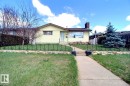 Front exterior with light yellow siding and a prominent brick chimney - 9512 134 Avenue, Edmonton, AB  - Outdoor 