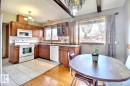 Kitchen featuring honey-toned cabinetry and a white appliance suite - 9512 134 Avenue, Edmonton, AB  - Indoor 