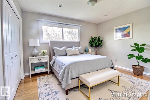 Spacious room featuring wood-finish flooring, a large window, bi-fold closet doors, recessed lighting, and a semi-flush mount ceiling fixture - 9512 134 Avenue, Edmonton, AB - Indoor Photo Showing Bedroom