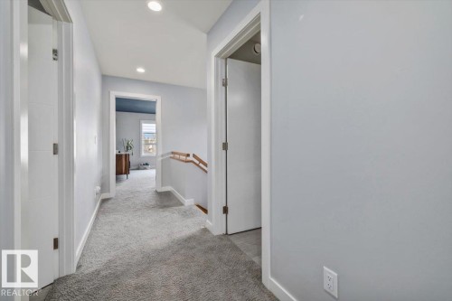 Carpeted hallway featuring recessed lighting, white baseboards, and white paneled doors - 11245 64 Street, Edmonton, AB - Indoor Photo Showing Other Room