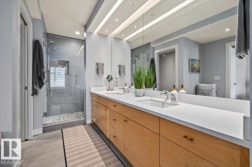 Spacious bathroom with a double vanity featuring light wood-finish cabinetry and white countertops - 11245 64 Street, Edmonton, AB - Indoor Photo Showing Bathroom