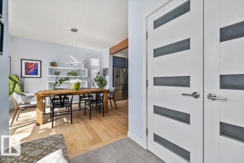 Modern interior doors with frosted glass panels, brushed nickel hardware, and light wood-finish flooring - 11245 64 Street, Edmonton, AB - Indoor