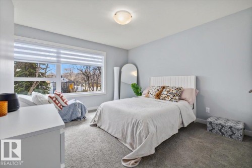 Bright room featuring a large window with horizontal blinds, light gray walls, and gray carpet flooring - 11245 64 Street, Edmonton, AB - Indoor Photo Showing Bedroom