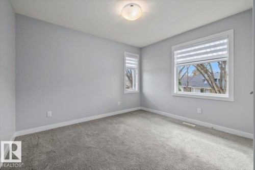 Grey carpeting complements light grey walls with white trim - 11245 64 Street, Edmonton, AB - Indoor Photo Showing Other Room