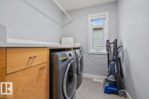 Laundry area featuring wood-finish cabinetry, a white countertop, and a single window - 11245 64 Street, Edmonton, AB - Indoor Photo Showing Laundry Room