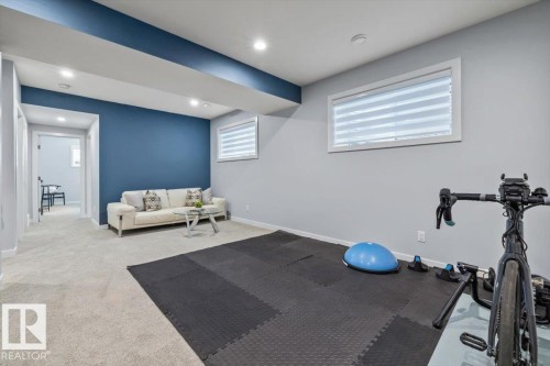 Spacious room featuring light gray carpeting and a contrasting accent wall - 11245 64 Street, Edmonton, AB - Indoor