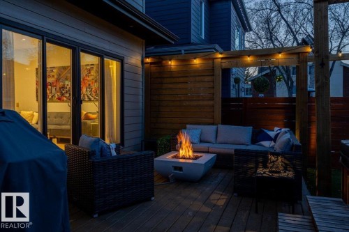 Expansive wood deck with a built-in hot tub, privacy fencing, a slatted wood pergola, and a fire pit - 11245 64 Street, Edmonton, AB - Outdoor With Deck Patio Veranda With Exterior