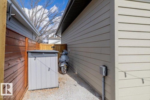 Gravel pathway featuring a privacy fence, a built-in storage unit, and exterior siding - 11245 64 Street, Edmonton, AB - Outdoor With Exterior