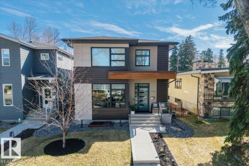 Modern architectural design featuring horizontal siding, a prominent wood-finish accent, and multiple large windows - 11245 64 Street, Edmonton, AB - Outdoor