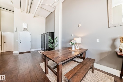 Open-concept room featuring wood-finish flooring, exposed ceiling ductwork, and high ceilings - 1003 10179 105 Street Nw, Edmonton, AB - Indoor
