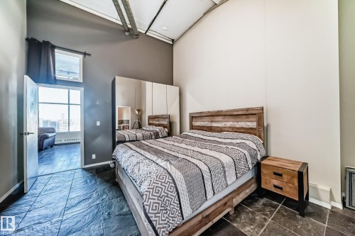 Bedroom featuring textured tile flooring and high ceilings with exposed ductwork - 1003 10179 105 Street Nw, Edmonton, AB - Indoor Photo Showing Bedroom