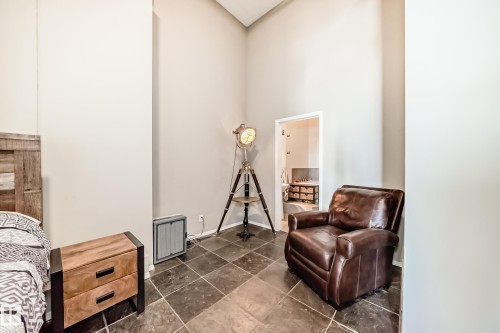 Vaulted ceiling room with dark square tile flooring - 1003 10179 105 Street Nw, Edmonton, AB - Indoor