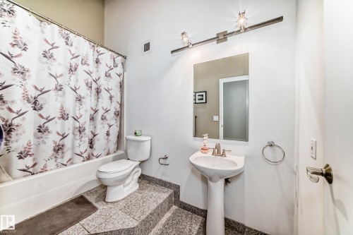 Pedestal sink with polished chrome faucet, rectangular wall mirror, and track lighting fixture - 1003 10179 105 Street Nw, Edmonton, AB - Indoor Photo Showing Bathroom