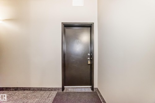 Entry door featuring a dark finish and modern hardware - 1003 10179 105 Street Nw, Edmonton, AB - Indoor Photo Showing Other Room