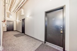 Common area hallway featuring durable carpet tile flooring and sconce lighting - 