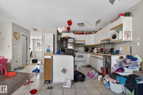 Kitchen featuring white cabinetry, a built-in microwave, and a stainless steel dishwasher - 64 3311 58 Street, Edmonton, AB - Indoor Photo Showing Kitchen