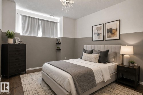 Bedroom featuring wood-finish flooring, two-tone wall treatment, and a contemporary chandelier - 64 3311 58 Street, Edmonton, AB - Indoor Photo Showing Bedroom