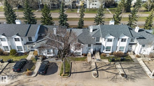 Townhouse complex featuring multiple units with white siding and dark shingle roofs - 64 3311 58 Street, Edmonton, AB - Outdoor