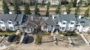 Townhouse complex featuring multiple units with white siding and dark shingle roofs - 64 3311 58 Street, Edmonton, AB  - Outdoor 
