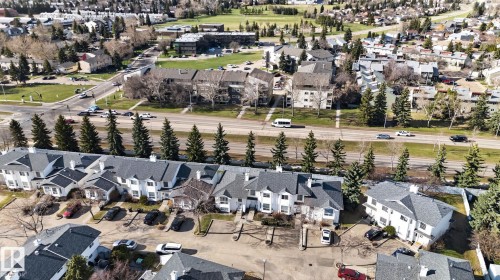 Aerial perspective showcasing multiple townhouse units with gray roofs and white siding - 64 3311 58 Street, Edmonton, AB - Outdoor With View