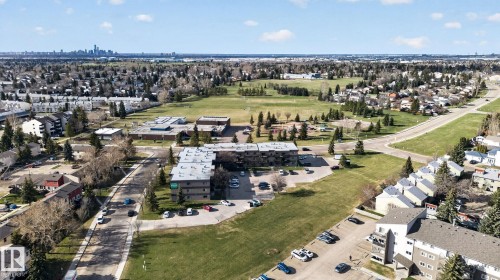 Aerial perspective showcasing a multi-building residential complex surrounded by green spaces and residential streets - 64 3311 58 Street, Edmonton, AB - Outdoor With View