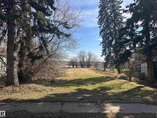 Cleared lot featuring established evergreen trees and natural vegetation - 5013 50 Avenue, Fawcett, AB 