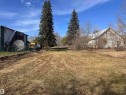 Expansive open lot featuring mature evergreen trees and a direct access path - 5013 50 Avenue, Fawcett, AB 