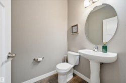 Pedestal sink with chrome faucet, oval mirror, and overhead vanity lighting - 